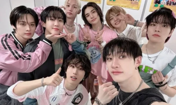 Can you identify which member of Stray Kids is concealed behind the girl's image?                                        